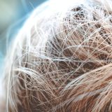 a close up of a person's hair with a blurry background